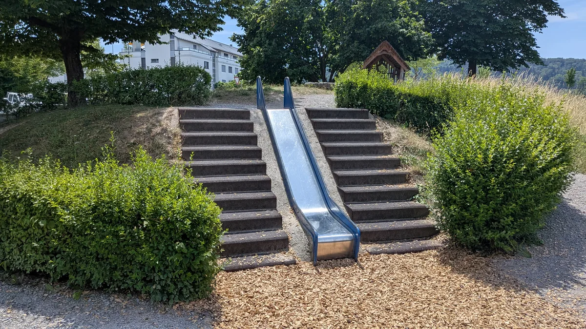 Es hat einen Hügel, also baute man eine Rutsche hin. Impressionen aus einem Spielplatz.